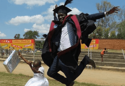 two graduating students jumping for joy