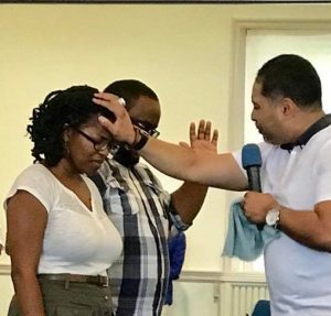 Temwa Wright being anointed by a pastor
