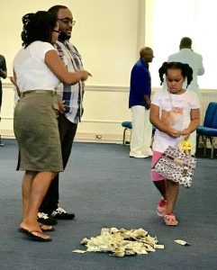 Temwa Wright and a little girl receiving mission trip donations at church