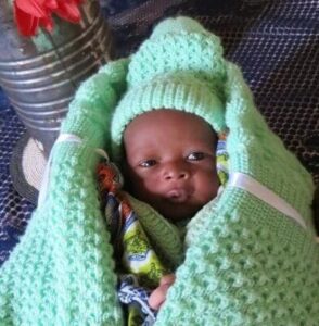 Junior smiling while wrapped in a green blanket